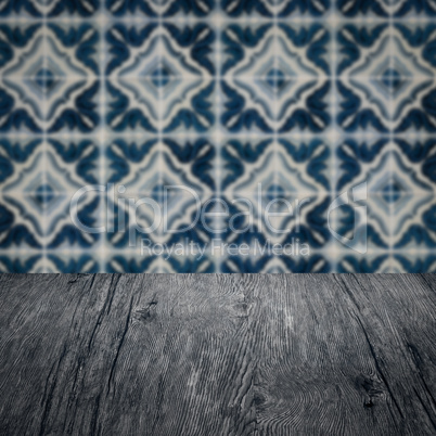 Wood table top and blur vintage ceramic tile pattern wall