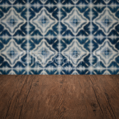 Wood table top and blur vintage ceramic tile pattern wall