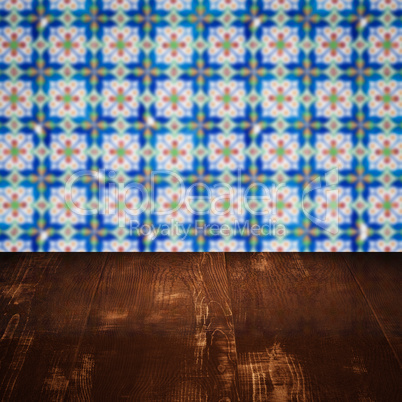 Wood table top and blur vintage ceramic tile pattern wall