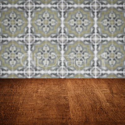 Wood table top and blur vintage ceramic tile pattern wall