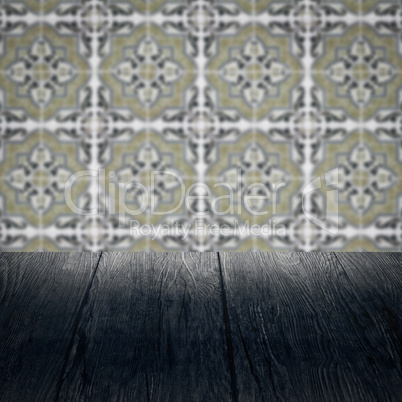 Wood table top and blur vintage ceramic tile pattern wall