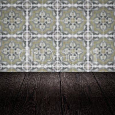 Wood table top and blur vintage ceramic tile pattern wall