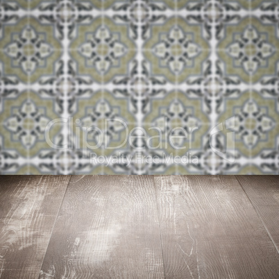 Wood table top and blur vintage ceramic tile pattern wall