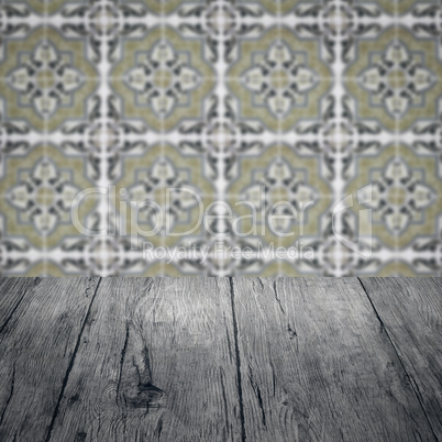 Wood table top and blur vintage ceramic tile pattern wall