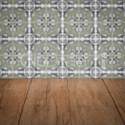 Wood table top and blur vintage ceramic tile pattern wall Wood table top and blur vintage ceramic tile pattern wall