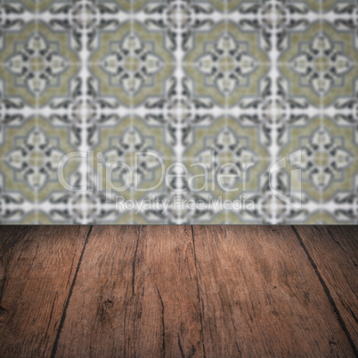 Wood table top and blur vintage ceramic tile pattern wall