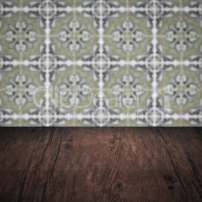 Wood table top and blur vintage ceramic tile pattern wall