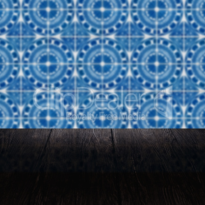 Wood table top and blur vintage ceramic tile pattern wall