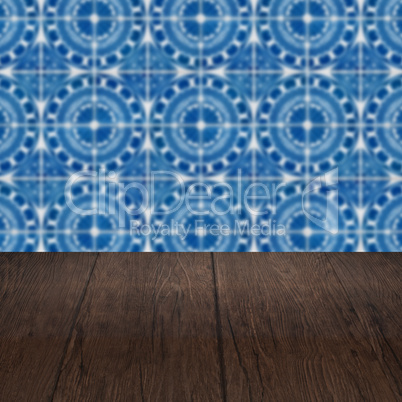 Wood table top and blur vintage ceramic tile pattern wall