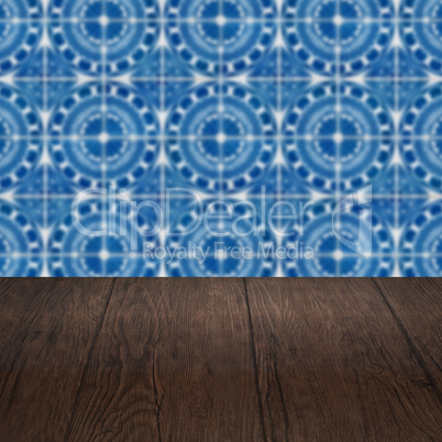 Wood table top and blur vintage ceramic tile pattern wall