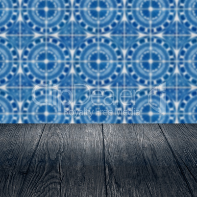 Wood table top and blur vintage ceramic tile pattern wall