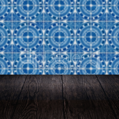 Wood table top and blur vintage ceramic tile pattern wall