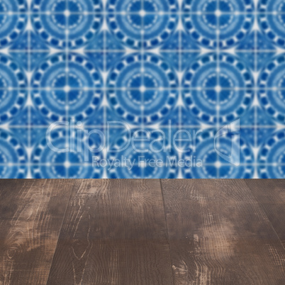 Wood table top and blur vintage ceramic tile pattern wall