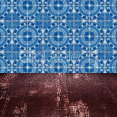 Wood table top and blur vintage ceramic tile pattern wall Wood table top and blur vintage ceramic tile pattern wall