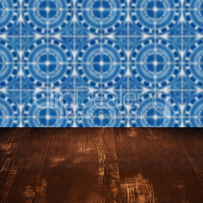 Wood table top and blur vintage ceramic tile pattern wall