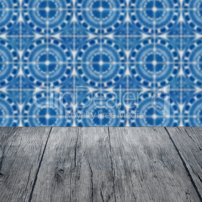 Wood table top and blur vintage ceramic tile pattern wall