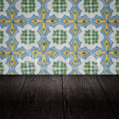 Wood table top and blur vintage ceramic tile pattern wall Wood table top and blur vintage ceramic tile pattern wall