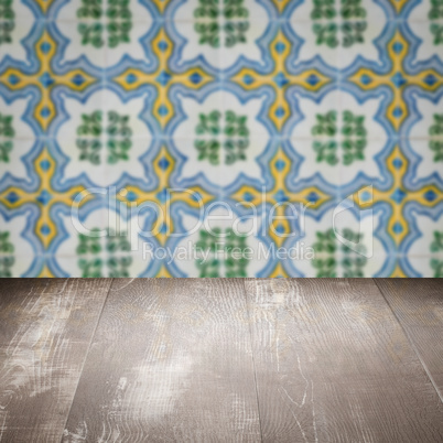 Wood table top and blur vintage ceramic tile pattern wall