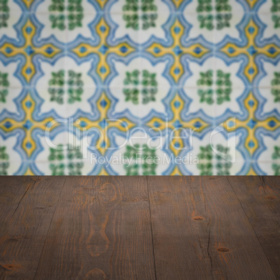 Wood table top and blur vintage ceramic tile pattern wall