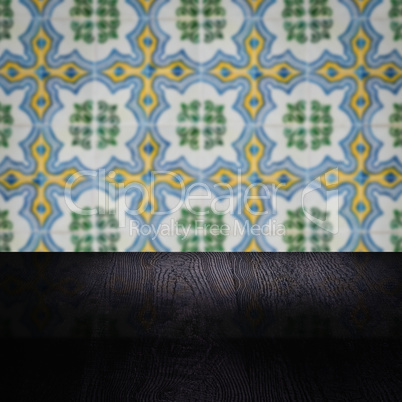 Wood table top and blur vintage ceramic tile pattern wall