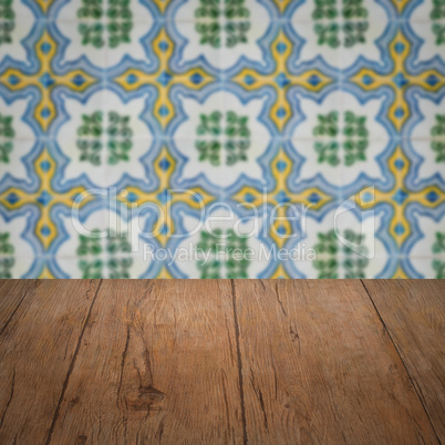 Wood table top and blur vintage ceramic tile pattern wall