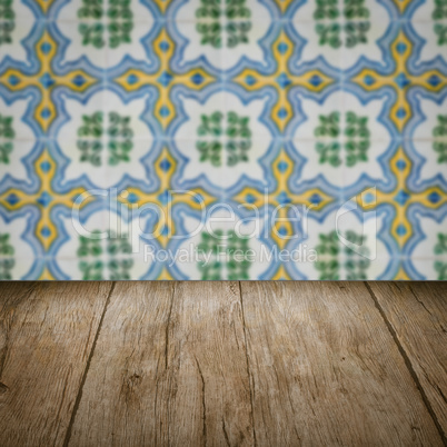 Wood table top and blur vintage ceramic tile pattern wall Wood table top and blur vintage ceramic tile pattern wall