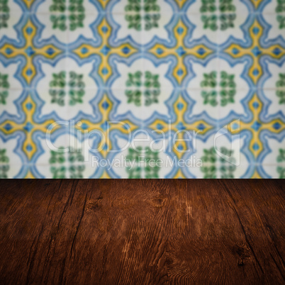 Wood table top and blur vintage ceramic tile pattern wall