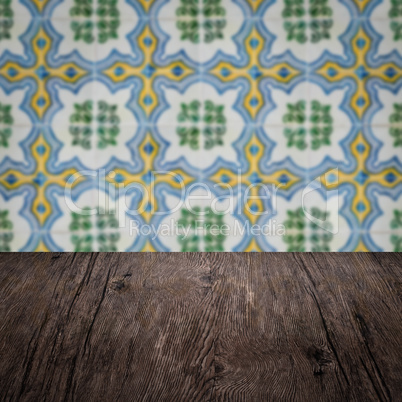 Wood table top and blur vintage ceramic tile pattern wall