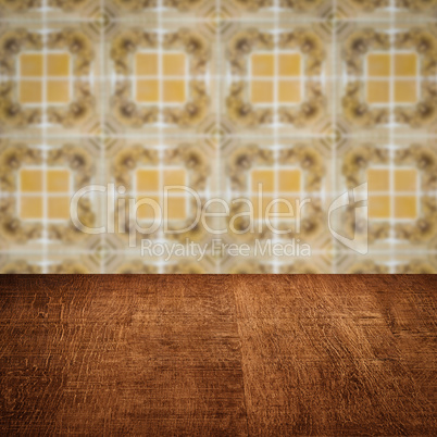 Wood table top and blur vintage ceramic tile pattern wall