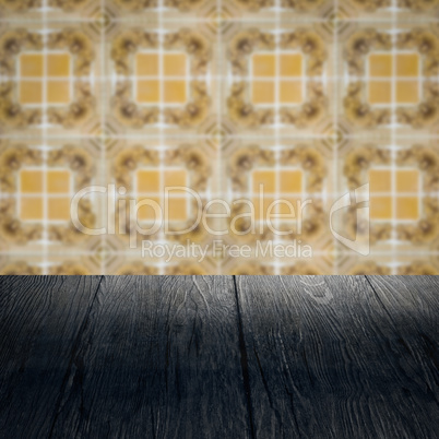 Wood table top and blur vintage ceramic tile pattern wall Wood table top and blur vintage ceramic tile pattern wall
