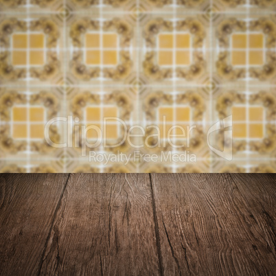 Wood table top and blur vintage ceramic tile pattern wall Wood table top and blur vintage ceramic tile pattern wall