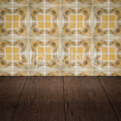 Wood table top and blur vintage ceramic tile pattern wall