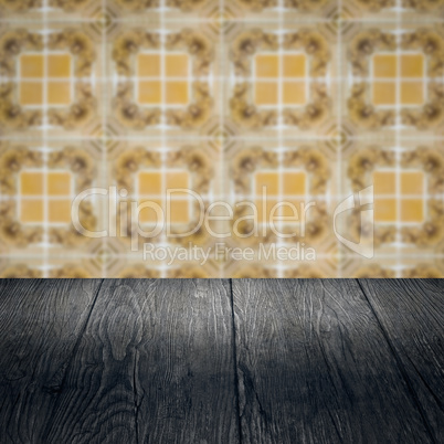 Wood table top and blur vintage ceramic tile pattern wall