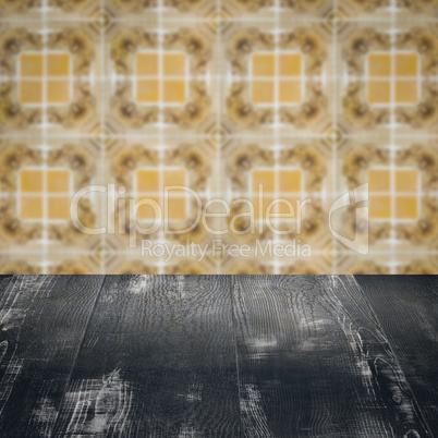 Wood table top and blur vintage ceramic tile pattern wall