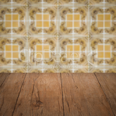 Wood table top and blur vintage ceramic tile pattern wall