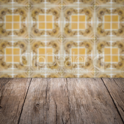 Wood table top and blur vintage ceramic tile pattern wall