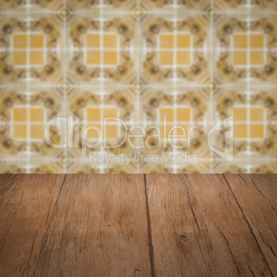 Wood table top and blur vintage ceramic tile pattern wall