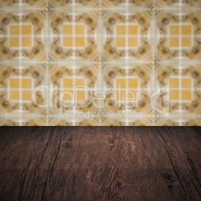 Wood table top and blur vintage ceramic tile pattern wall