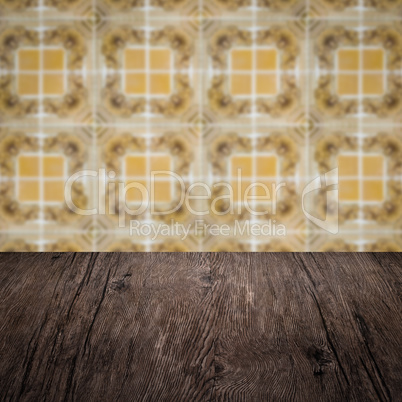 Wood table top and blur vintage ceramic tile pattern wall