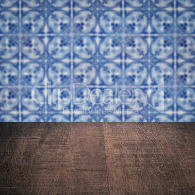 Wood table top and blur vintage ceramic tile pattern wall