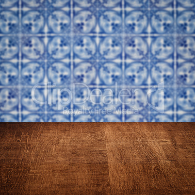 Wood table top and blur vintage ceramic tile pattern wall