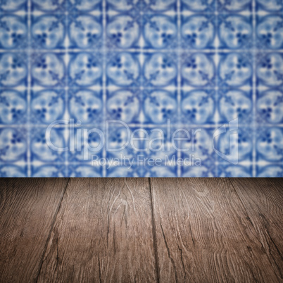 Wood table top and blur vintage ceramic tile pattern wall