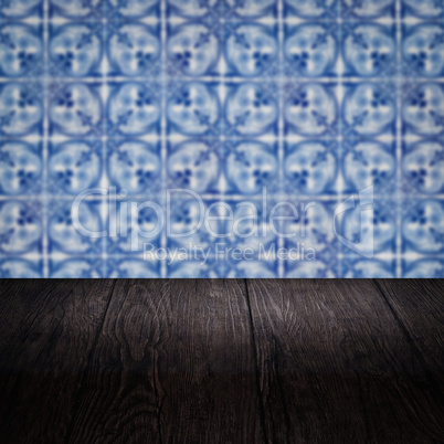 Wood table top and blur vintage ceramic tile pattern wall Wood table top and blur vintage ceramic tile pattern wall