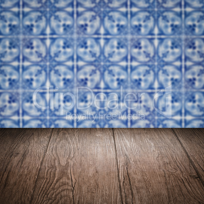 Wood table top and blur vintage ceramic tile pattern wall