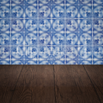 Wood table top and blur vintage ceramic tile pattern wall