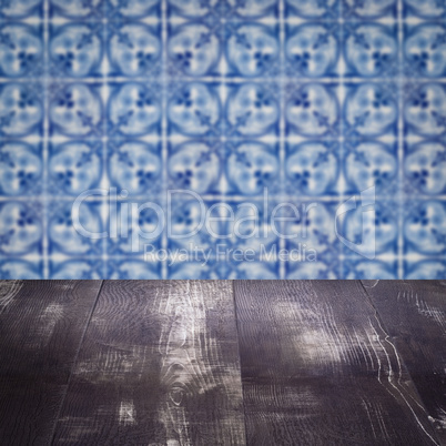 Wood table top and blur vintage ceramic tile pattern wall