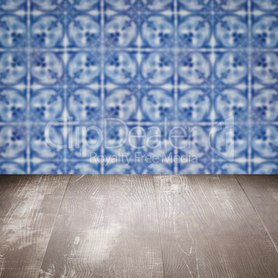 Wood table top and blur vintage ceramic tile pattern wall