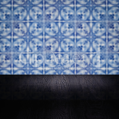 Wood table top and blur vintage ceramic tile pattern wall