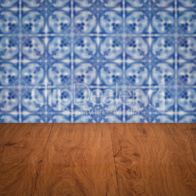 Wood table top and blur vintage ceramic tile pattern wall