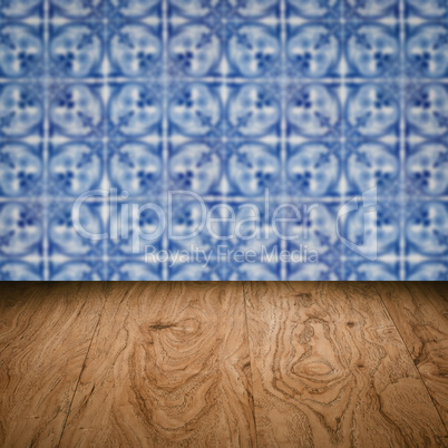 Wood table top and blur vintage ceramic tile pattern wall Wood table top and blur vintage ceramic tile pattern wall